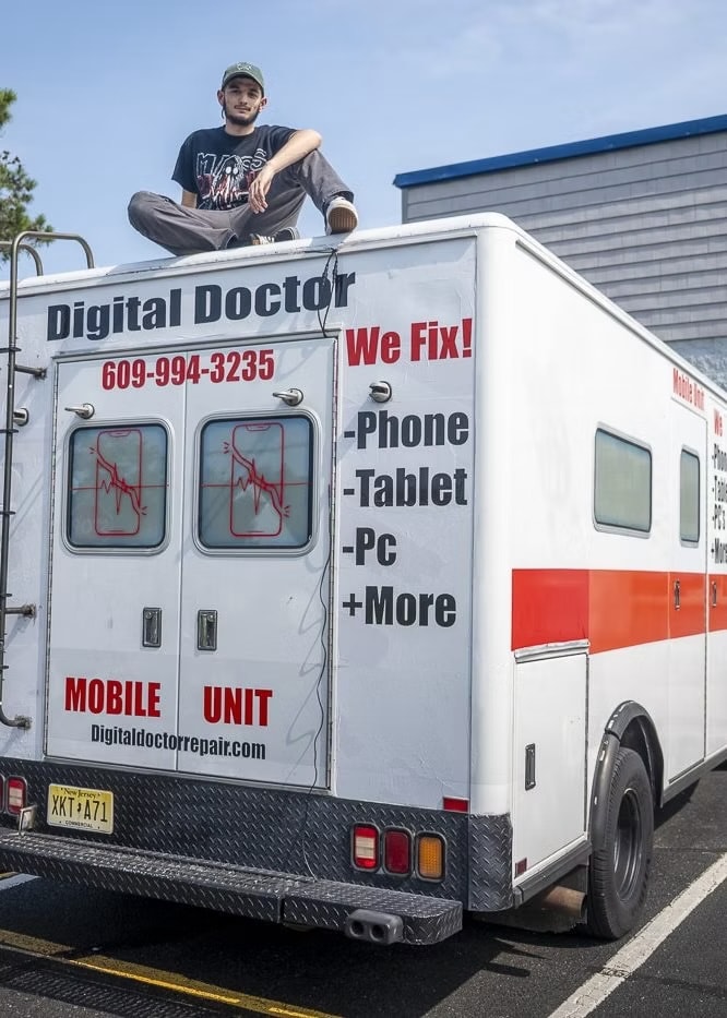 A Digital Doctor tech on the roof of the mobile repair unit