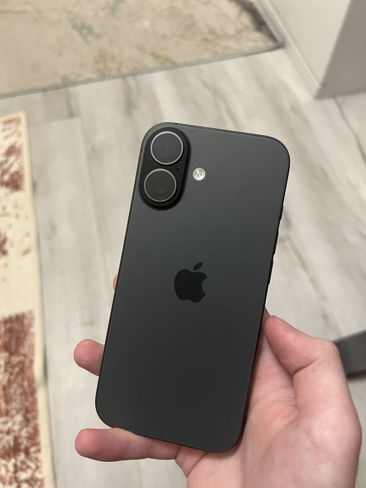 A repaired black iPhone held in a customer's hand